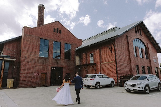 The wedding couple Jenna & Wishy approaching entrance to switch powerhouse adjacent to 1915 restaurant & bar geelong